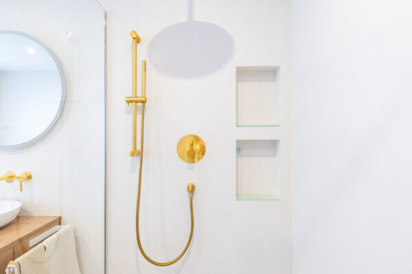 Fugenlose helle Duschwand mit goldener Brausearmatur, Basel – Malergenossenschaft Basel